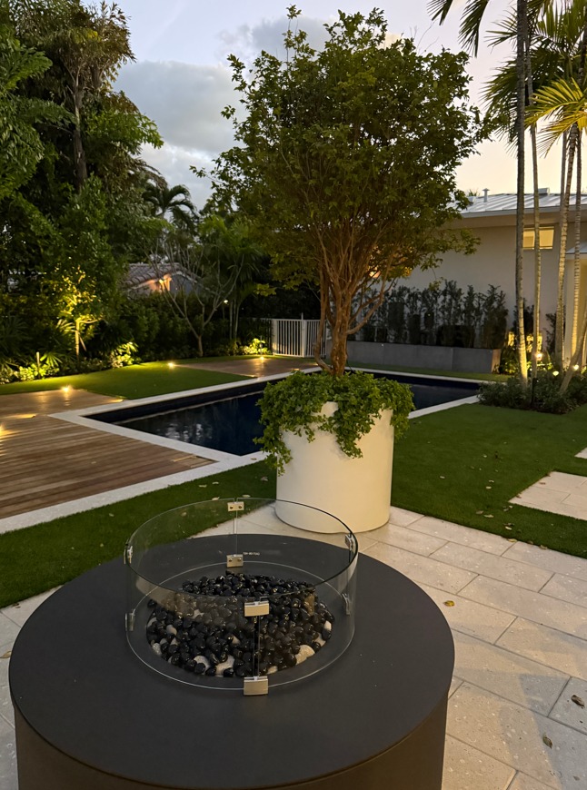 Fire pit y matera escultural con piscina al atardecer