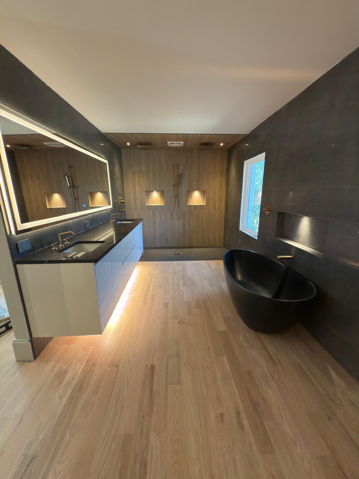 Baño principal con vanity flotante y acabados en piedra